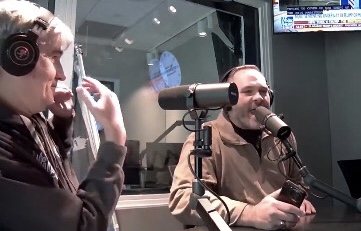 Newman Price in the studio wearing headphones and speaking into a microphone